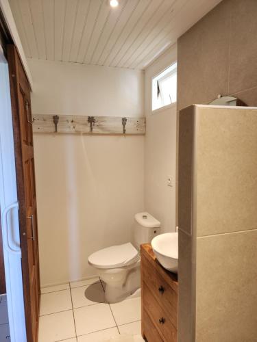 een kleine badkamer met een toilet en een wastafel bij Bungalow Tiare in Uturoa