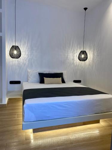 ein Schlafzimmer mit einem Bett mit zwei Leuchten in der Unterkunft Asteras Cozy Stay in Naoussa
