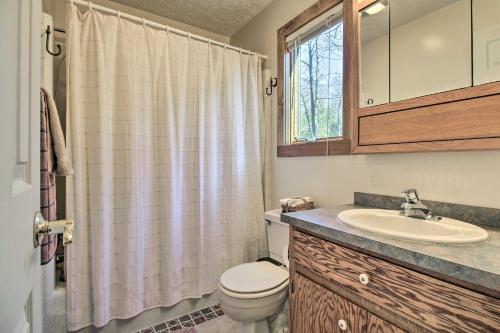 ein Bad mit einem WC, einem Waschbecken und einem Fenster in der Unterkunft Wintergreen Resort Retreat with Hot Tub! in Lyndhurst