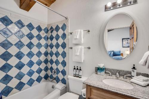 a bathroom with a tub and a sink and a mirror at Interlude Condominiums 3-Bedroom Unit 307 in Snowmass Village