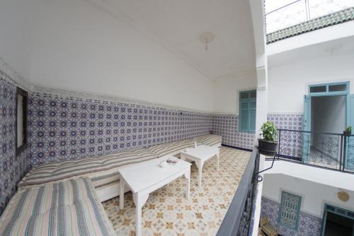 a room with blue and white tiled walls and benches at Hostel BE 20 in Marrakesh