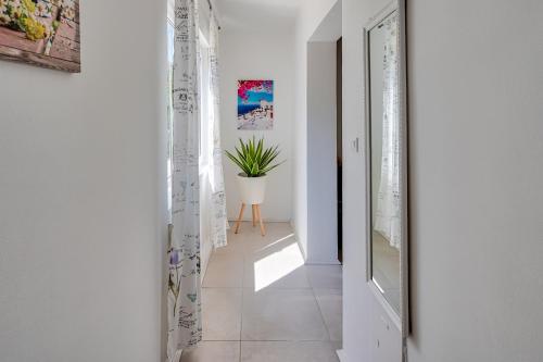 a hallway with white walls and a door with a potted plant at VILLA Matija in Ližnjan