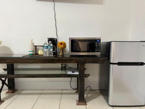 a microwave sitting on a table next to a refrigerator at Spacious Studio - minutes from MIA airport in Miami