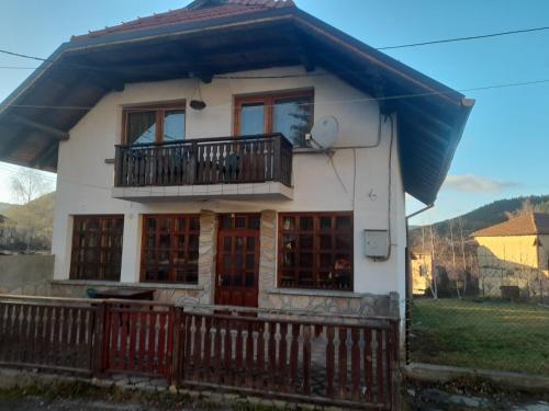 a small white house with a balcony at Къща за гости Дани in Govedartsi