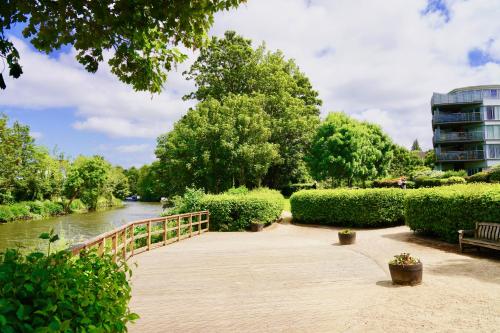 a bridge over a river with trees and a building at Riverside Apartment with Parking 1 Mile from Town Centre in Kent