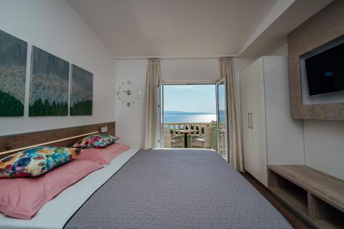 a bedroom with a bed with a view of the ocean at Apartments Tina in Brela