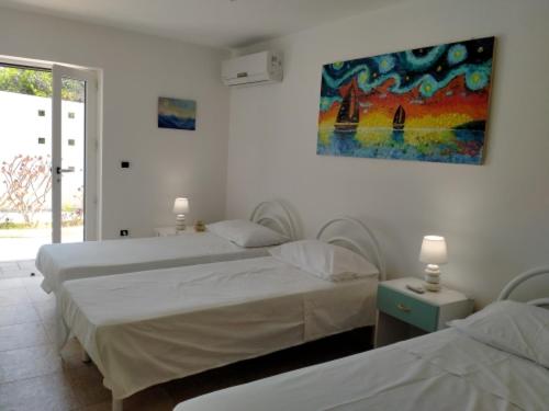 ガリポリにあるVele del Pizzo - piscinaのベッドルーム1室(ベッド2台付)が備わります。壁には絵画が飾られています。
