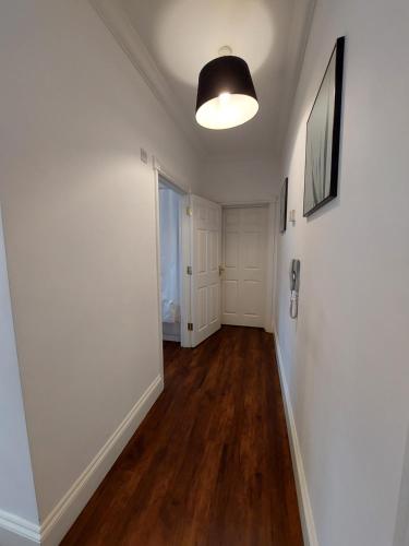 un pasillo vacío con paredes blancas y suelo de madera en Perceval House en Upton