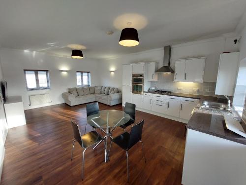 a kitchen and a living room with a table and chairs at Perceval House in Upton