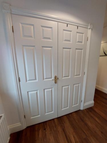 Armario blanco con puerta en una habitación en Perceval House en Upton