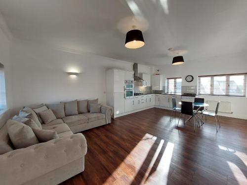 a large living room with a couch and a kitchen at Perceval House in Upton