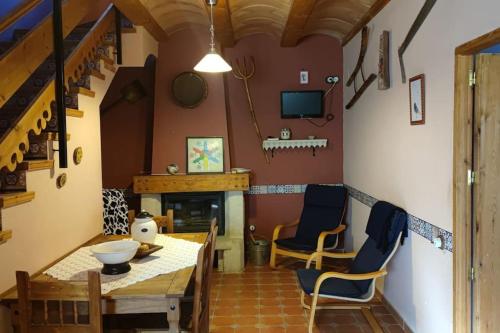 Montoro de Mezquita的住宿－Casa rural Vallore del Maestrazgo，客厅配有桌椅和壁炉
