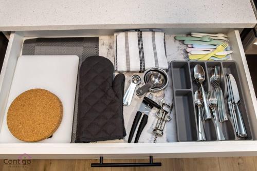 a drawer filled with cooking utensils and a casserole at Luxe New York Style Bsmt Suite, Near DT & WEM, King Bed, WiFi in Edmonton
