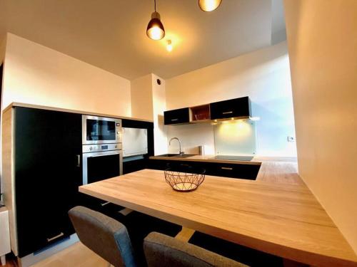 una cucina con tavolo e sedie in legno di Superbe appartement avec parking a Caen