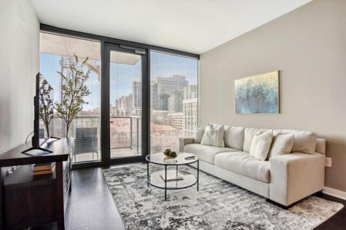 a living room with a couch and a large window at Piedmont Park 2 bdrm in Atlanta