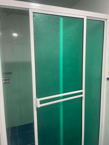 a green glass shower door in a bathroom at Hotel Pass, Laureles Medellín in Medellín