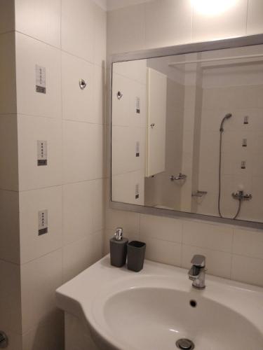a bathroom with a sink and a mirror at SKY AND SEA APARTMENT in Xylokastro