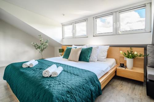 a bedroom with a bed with towels on it at Apartamenty Mieszka I in Łódź