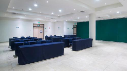 a conference room with blue chairs and a green screen at Holiday Inn Express Xalapa by IHG in Xalapa