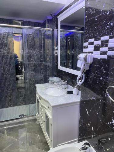een badkamer met een wastafel, een douche en een spiegel bij Elina’s Puteoli House in Pozzuoli