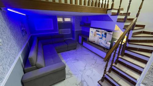 een kamer met een bank en een trap met blauwe verlichting bij Elina’s Puteoli House in Pozzuoli