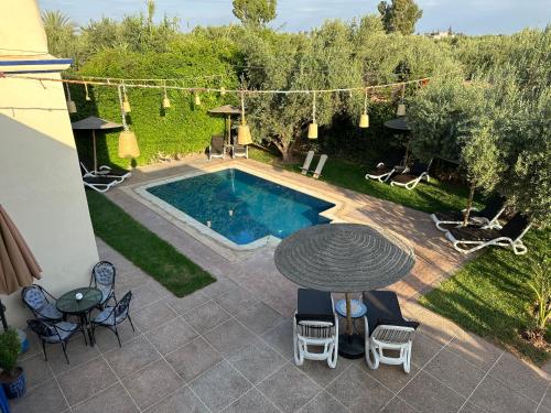 a patio with a table and chairs and a pool at Oasis Merasi Marrakech in Marrakesh