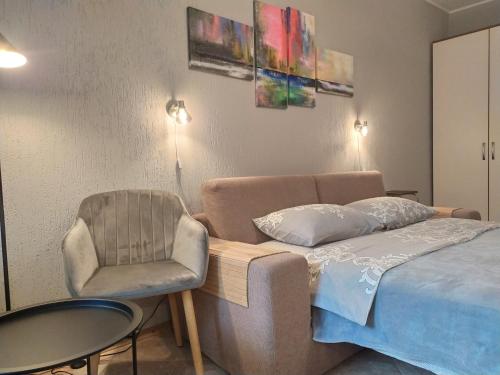 a bedroom with a bed and a chair and a table at Great view apartaments near Lavra in Kyiv