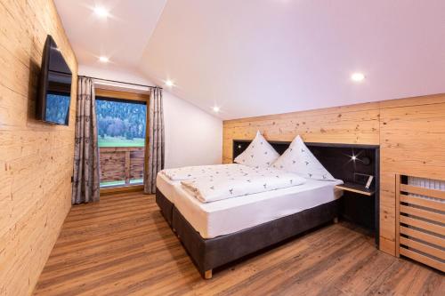 1 dormitorio con cama grande y ventana grande en Gasthof-Ferienwohnungen Dürrlehen, en Berchtesgaden