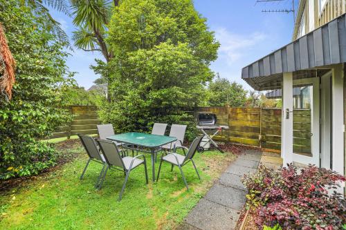 a patio with a table and chairs and a grill at Papawai Townhouse #11 in Rotorua