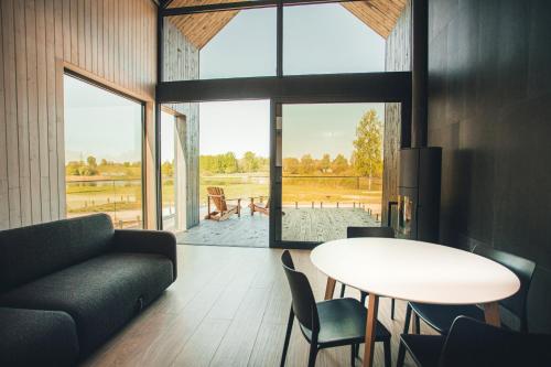 ein Wohnzimmer mit einem Sofa und einem Tisch in der Unterkunft WakeMālpils brīvdienu mājas in Mālpils