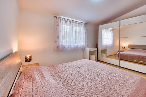 ein Schlafzimmer mit einem großen Bett und einem Spiegel in der Unterkunft Apartments Lara in Medulin