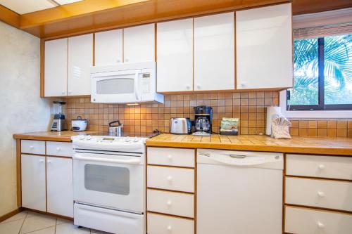 a kitchen with white appliances and a microwave at Kapalua Villas Maui in Lahaina