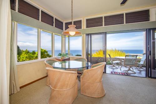 a dining room with a table and chairs and windows at Kapalua Villas Maui in Lahaina