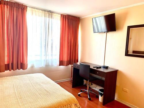 Habitación de hotel con 1 dormitorio con escritorio y 1 cama en CentriK Location Apartments Encomenderos 200, en Santiago