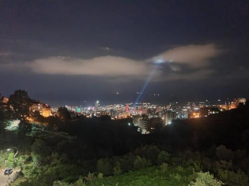 a city at night with a light in the sky at Stylish two bedroom house with private pool in Tirana