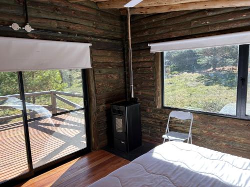 1 Schlafzimmer mit einem Bett, einem Kamin und einer Terrasse in der Unterkunft CABAÑA SIERRAS de CORDOBA in San Clemente