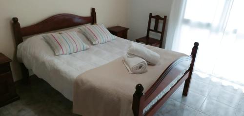 Un dormitorio con una cama con una toalla. en avellaneda suites en Río Gallegos
