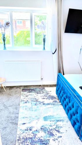 uma sala de estar com um sofá azul e um tapete em COSY DOUBLE ROOM em Manchester