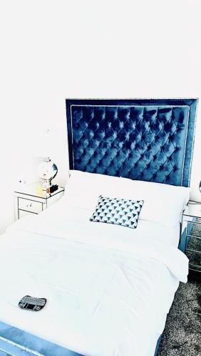 um quarto com uma cama com uma cabeceira azul em COSY DOUBLE ROOM em Manchester