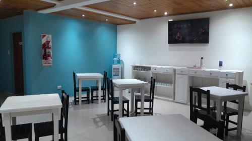 a dining room with tables and chairs and a blue wall at avellaneda suites in R&iacute;o Gallegos