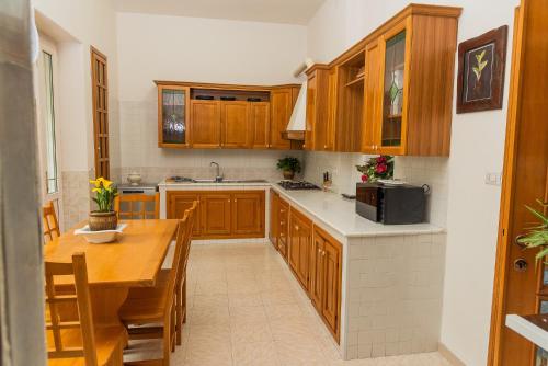 a kitchen with wooden cabinets and a wooden table at VILLA MAVI in Formia