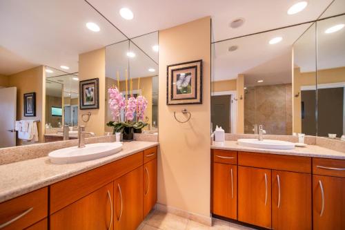 a bathroom with two sinks and two mirrors at Kapalua Villas Maui in Lahaina