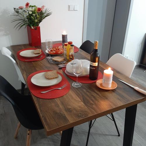 a wooden table with food and wine bottles and glasses at U Milana in Velké Bílovice
