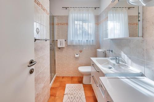 ein Bad mit einem Waschbecken, einem WC und einer Dusche in der Unterkunft Apartments Lara in Medulin