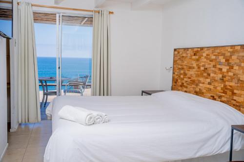 a bedroom with a bed and a view of the ocean at Cabañas Uma Qala de Primeras Piedras in Iquique