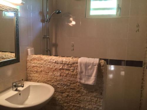 y baño con lavabo y ducha con espejo. en 1 bungalow en bois type chalet, en Sainte-Anne