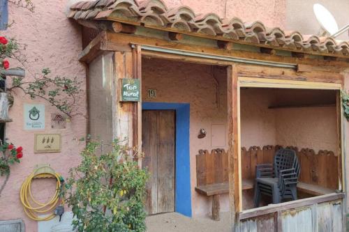 a house with a blue door and a chair on the porch at Casa Rural Obrador. in Montoro de Mezquita