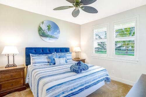 um quarto com uma cama azul e uma ventoinha de tecto em Pili Mai 8G em Kipu