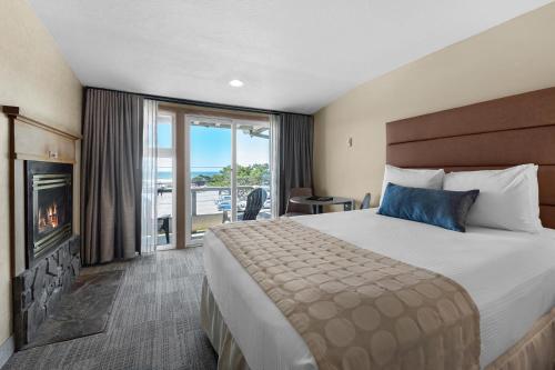 um quarto de hotel com uma cama e uma lareira em The Wayside Inn em Cannon Beach