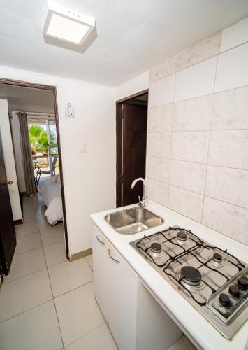 a kitchen with a sink and a stove top oven at Cabañas Uma Qala de Primeras Piedras in Iquique